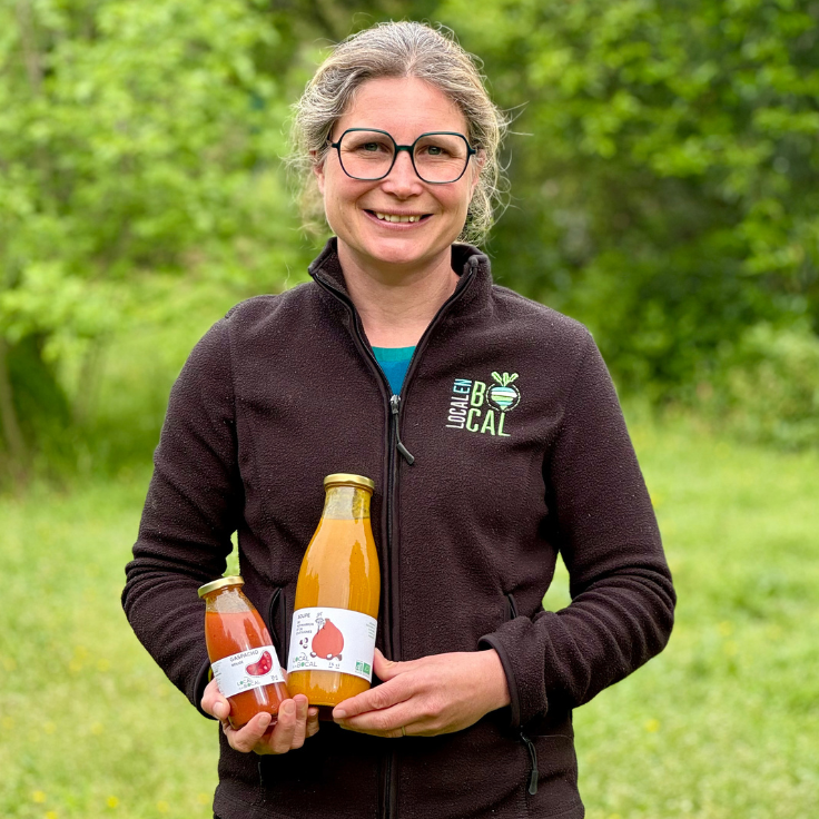 Productrice locale présentant ses jus et compotes maison